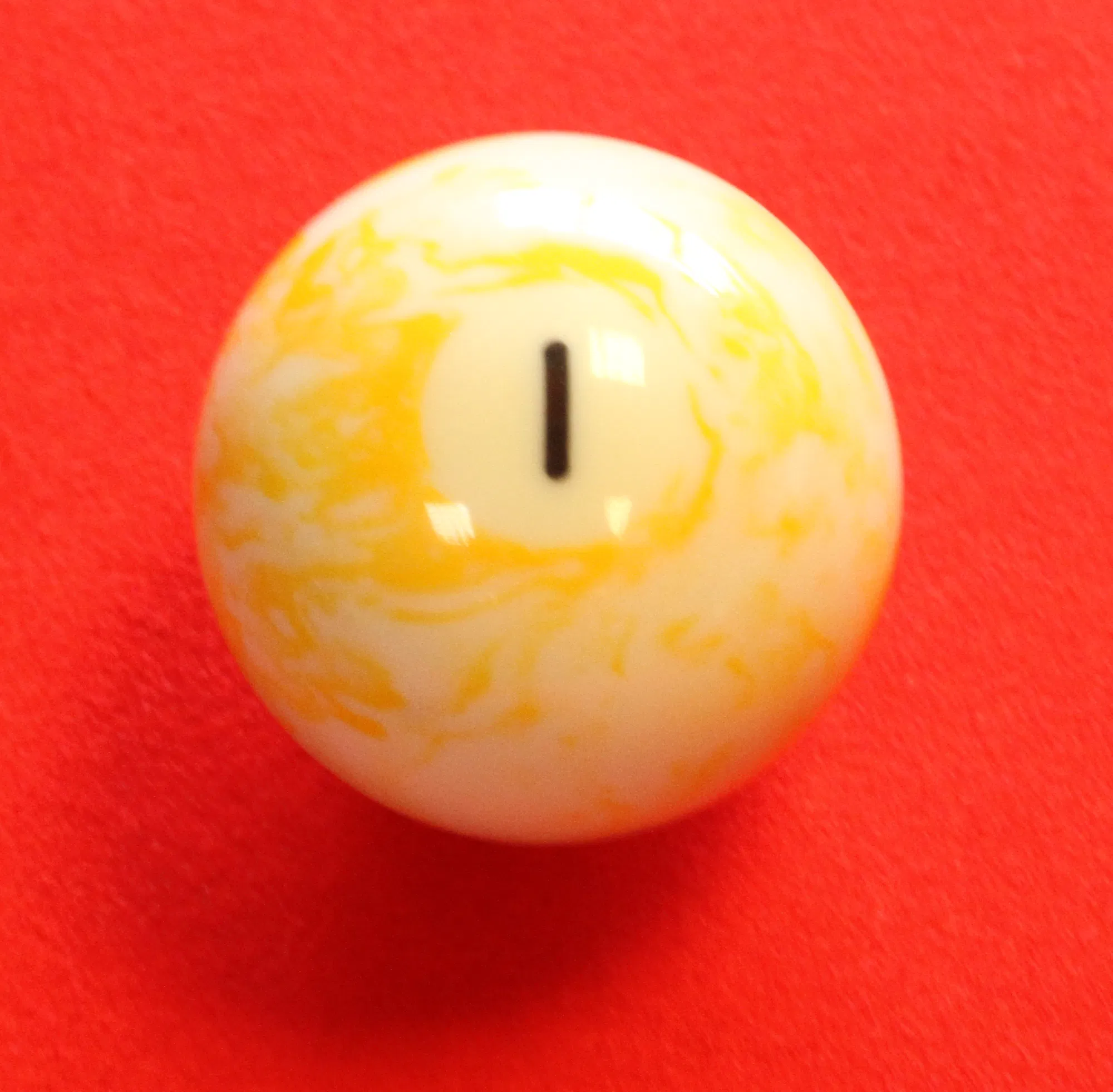 A vintage marbled 1 ball — the ball the cue ball must carom off and into a called pocket for the winning point