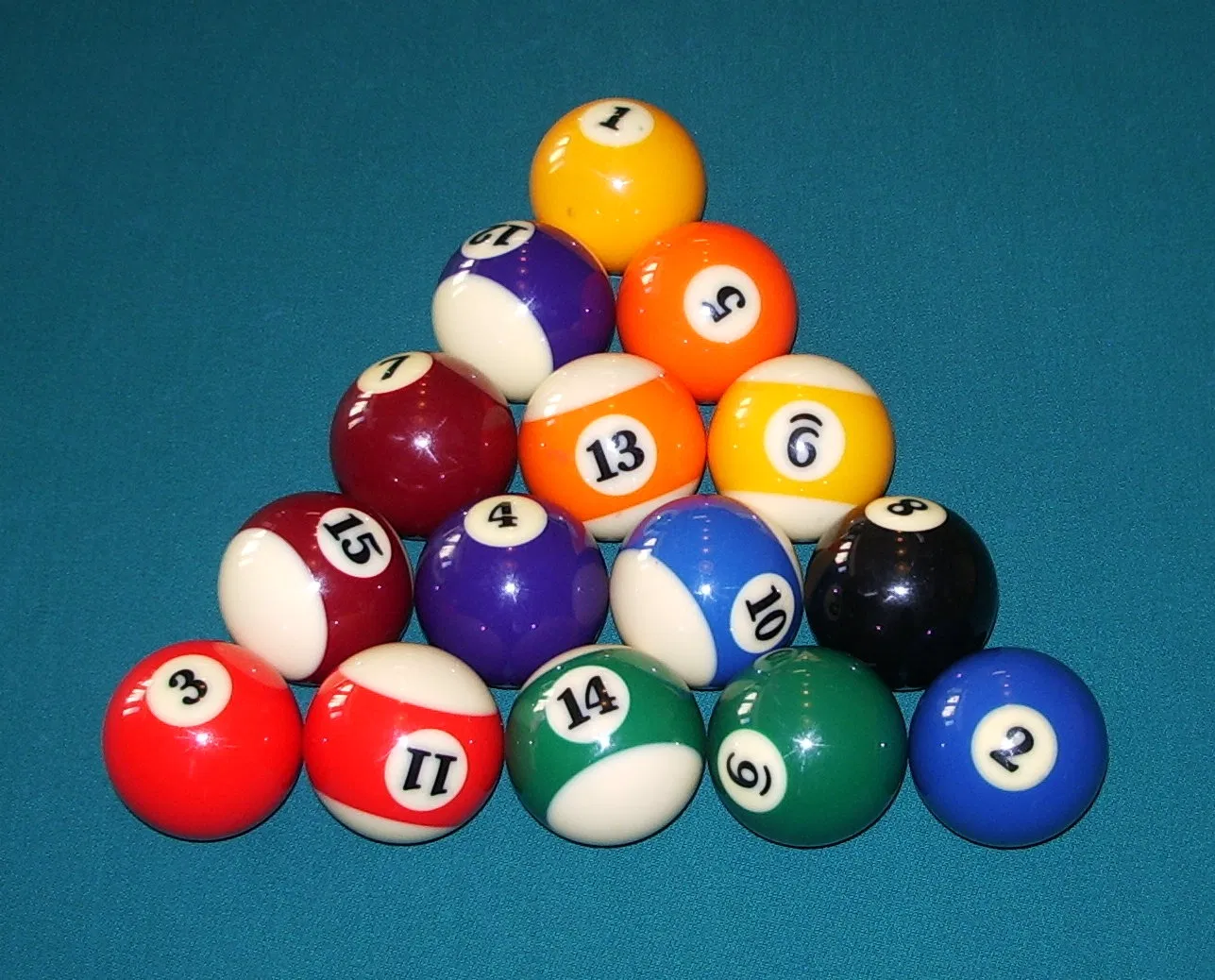One of many valid kelly pool racks — the 1 ball on the foot spot, the 2 and 3 on the back corners, all other balls random