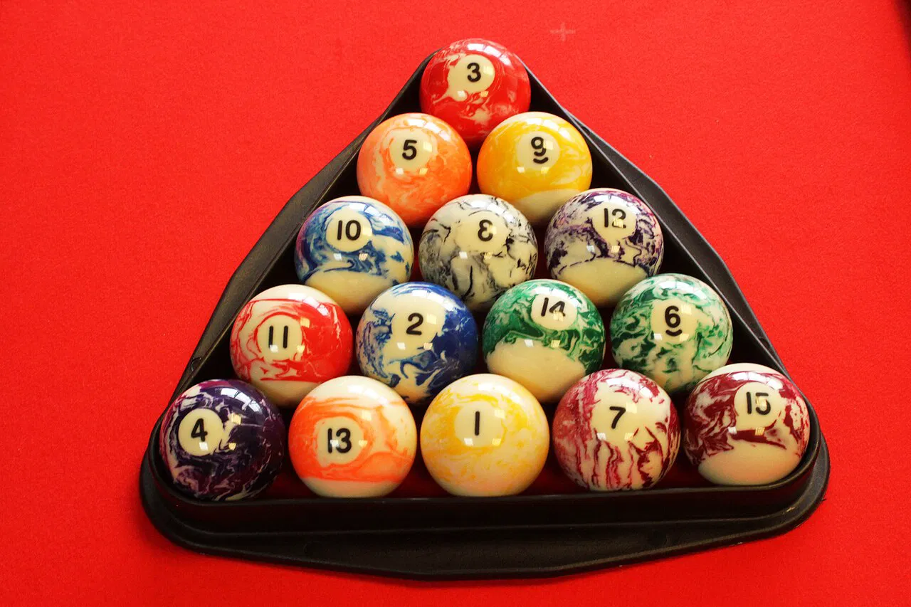 Fifteen pool balls in a tight triangle rack on red cloth, 8-ball in the center