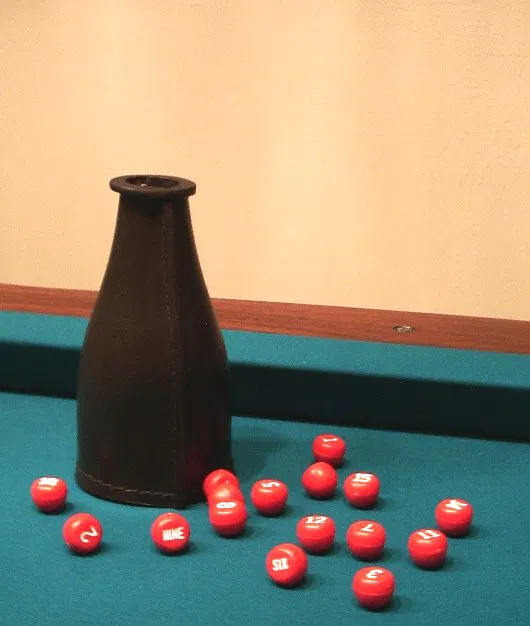 A leather shake bottle and numbered plastic peas used to draw secret balls in kelly pool